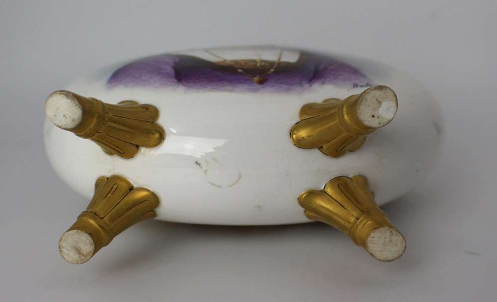 A white porcelain moon flask vase with twin gilded handles, four scroll feet, and a hand-painted portrait of a woman in a purple hat signed Baston. View XI