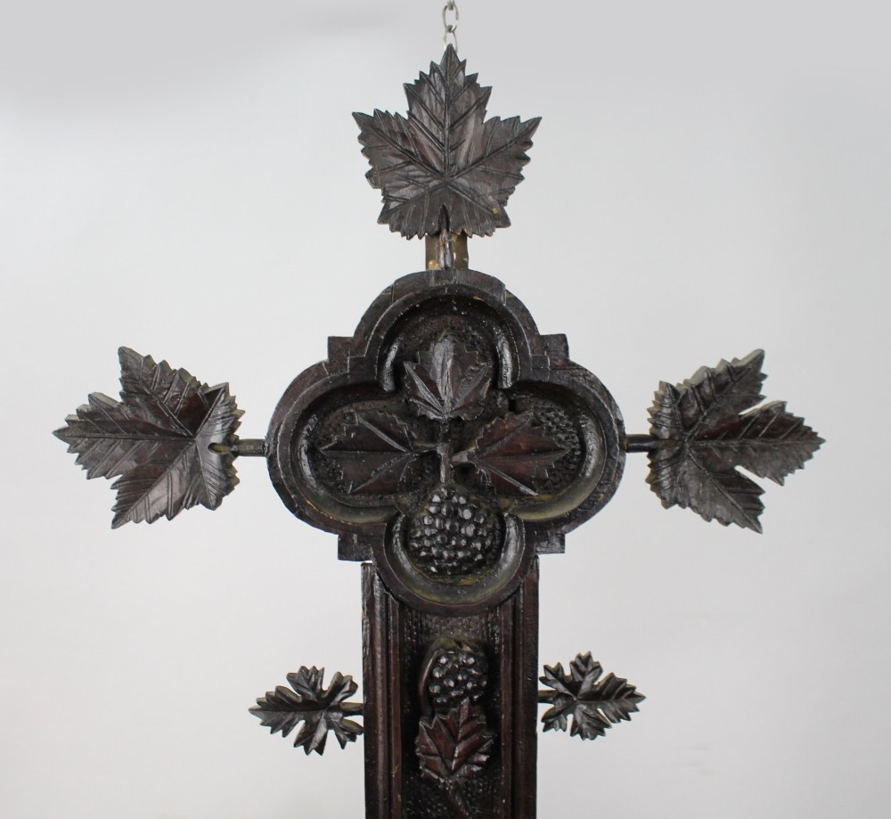 A 19th-century dark carved wood cross adorned with detailed foliate motifs and a gilt INRI inscription at the upper section. View III