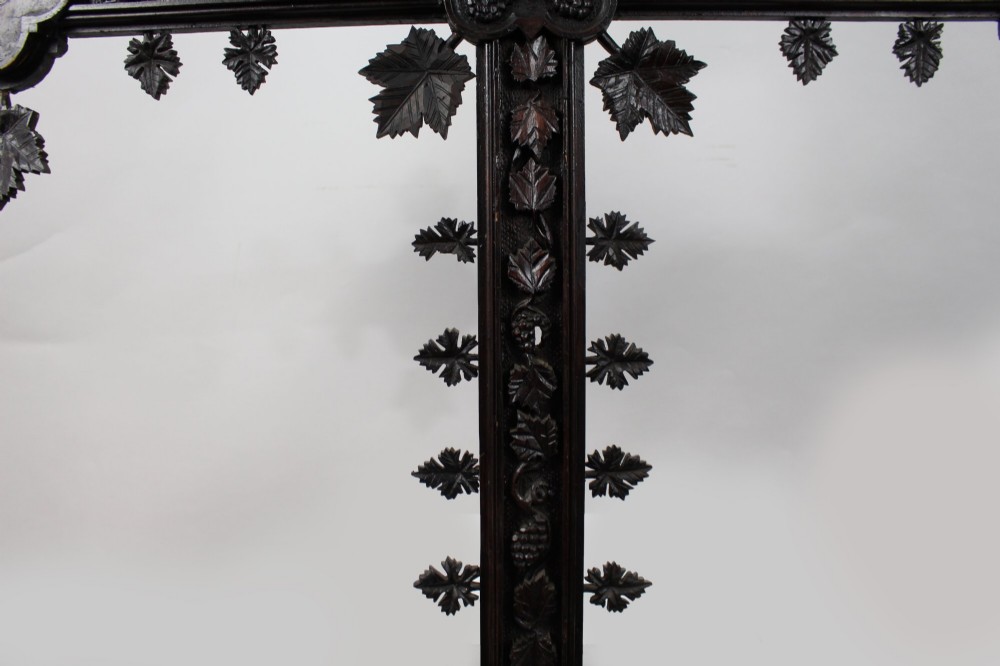 A 19th-century dark carved wood cross adorned with detailed foliate motifs and a gilt INRI inscription at the upper section. View V