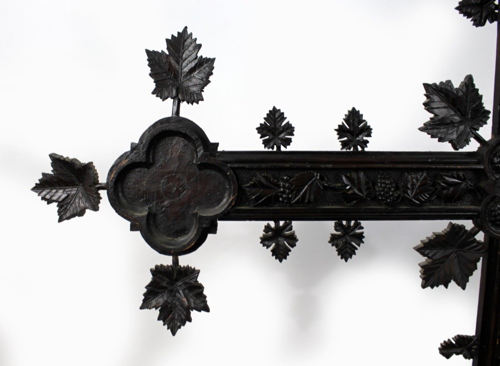 A 19th-century dark carved wood cross adorned with detailed foliate motifs and a gilt INRI inscription at the upper section. View VI