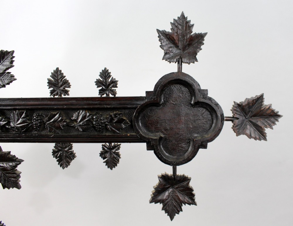 A 19th-century dark carved wood cross adorned with detailed foliate motifs and a gilt INRI inscription at the upper section. View VIII
