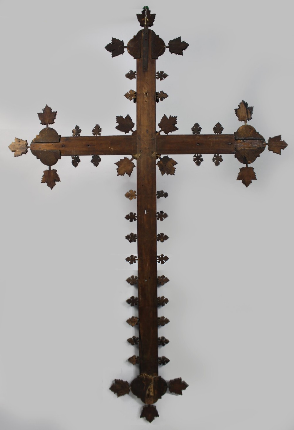 A 19th-century dark carved wood cross adorned with detailed foliate motifs and a gilt INRI inscription at the upper section. View X