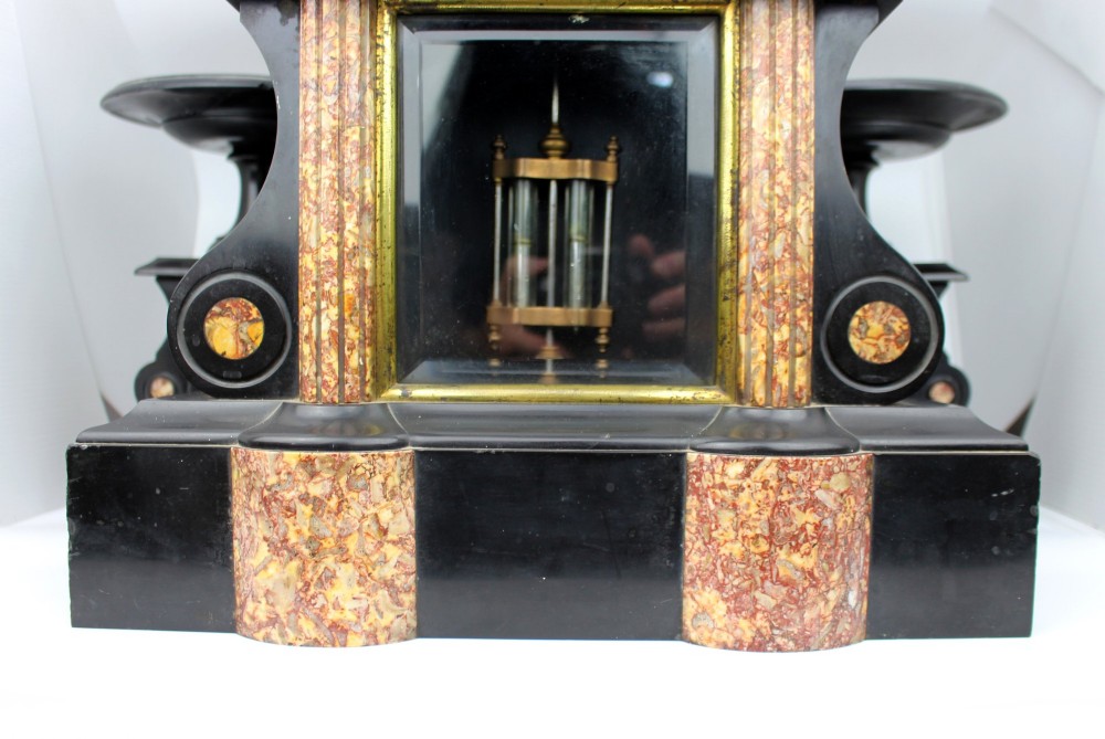 A 19th-century French black slate and red variegated marble clock garniture set with a central architectural clock and flanking side tazzas. View IV