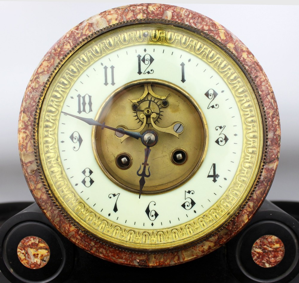 A 19th-century French black slate and red variegated marble clock garniture set with a central architectural clock and flanking side tazzas. View V