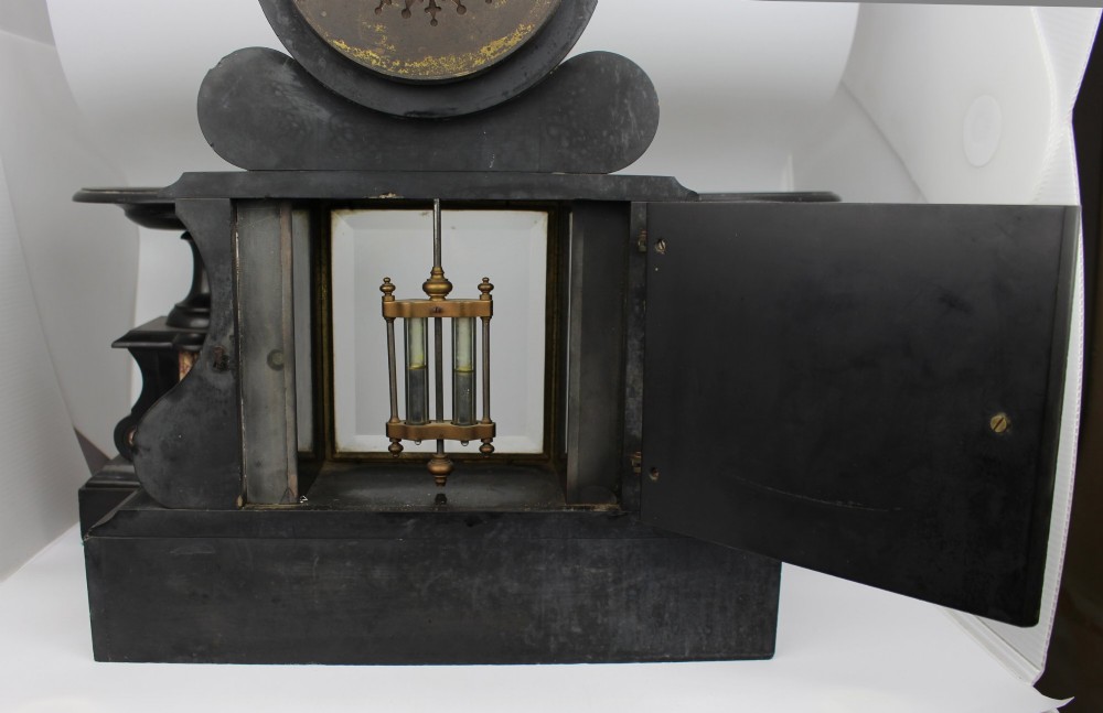 A 19th-century French black slate and red variegated marble clock garniture set with a central architectural clock and flanking side tazzas. View VII