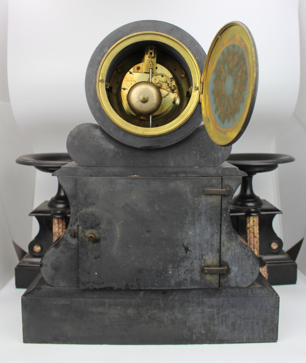 A 19th-century French black slate and red variegated marble clock garniture set with a central architectural clock and flanking side tazzas. View VIII