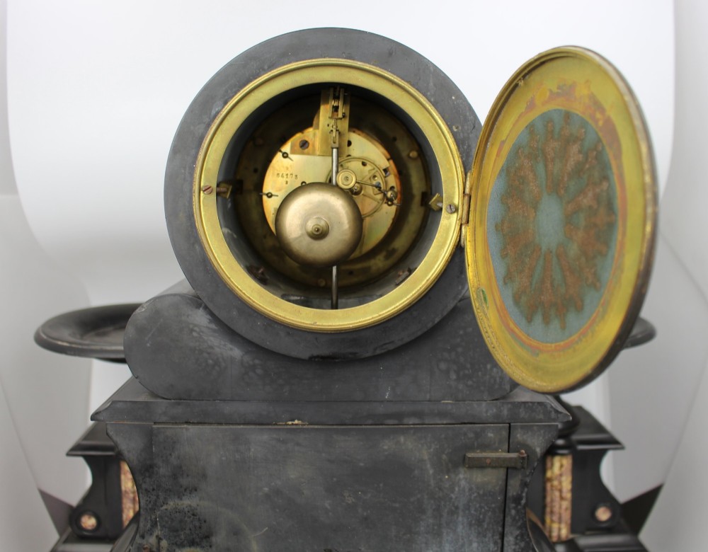 A 19th-century French black slate and red variegated marble clock garniture set with a central architectural clock and flanking side tazzas. View X