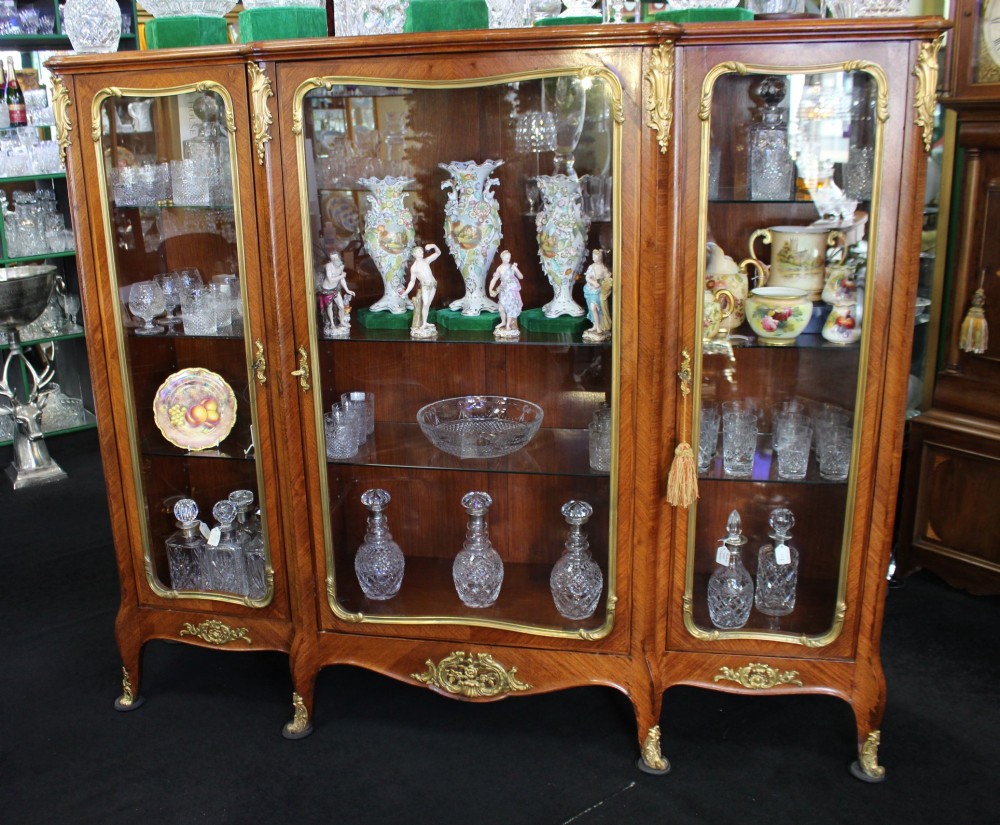 A large French kingwood display cabinet featuring three glass doors, gilded bronze mounts, and cabriole legs. View II