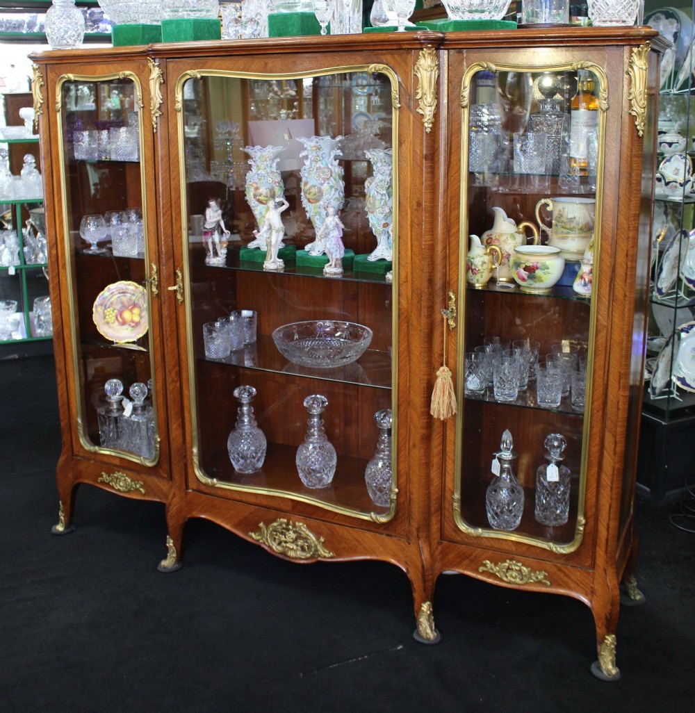 A large French kingwood display cabinet featuring three glass doors, gilded bronze mounts, and cabriole legs. View III