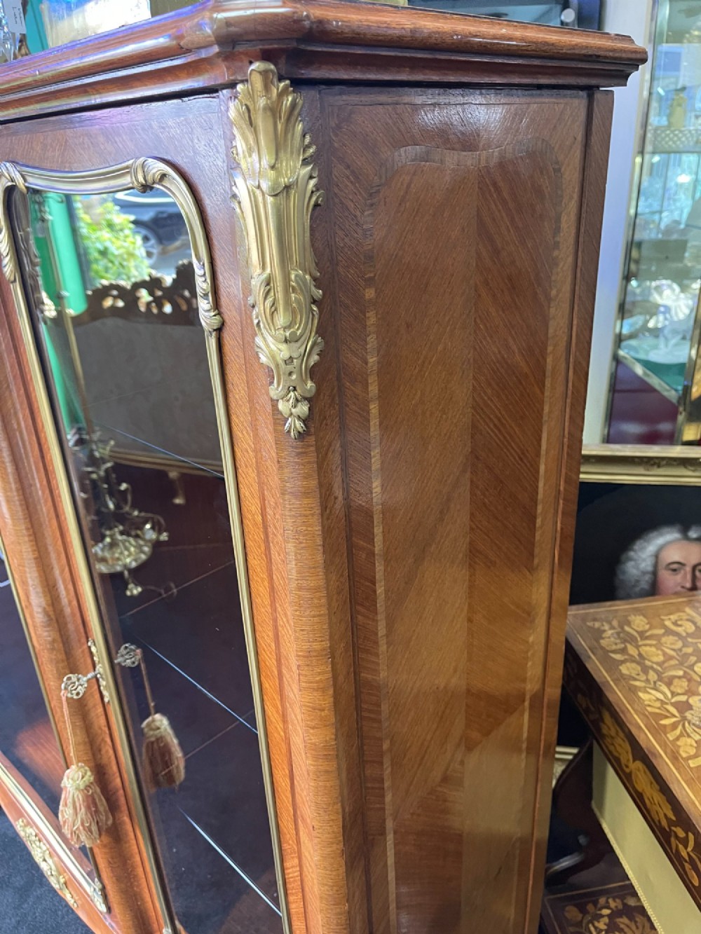 A large French kingwood display cabinet featuring three glass doors, gilded bronze mounts, and cabriole legs. View XIII