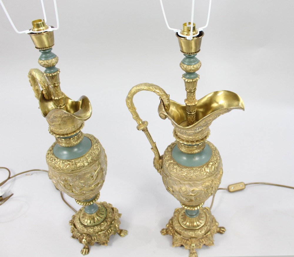 A pair of late nineteenth-century gilt metal table lamps fashioned in the shape of classical ewers with relief carving and green painted accents. View III