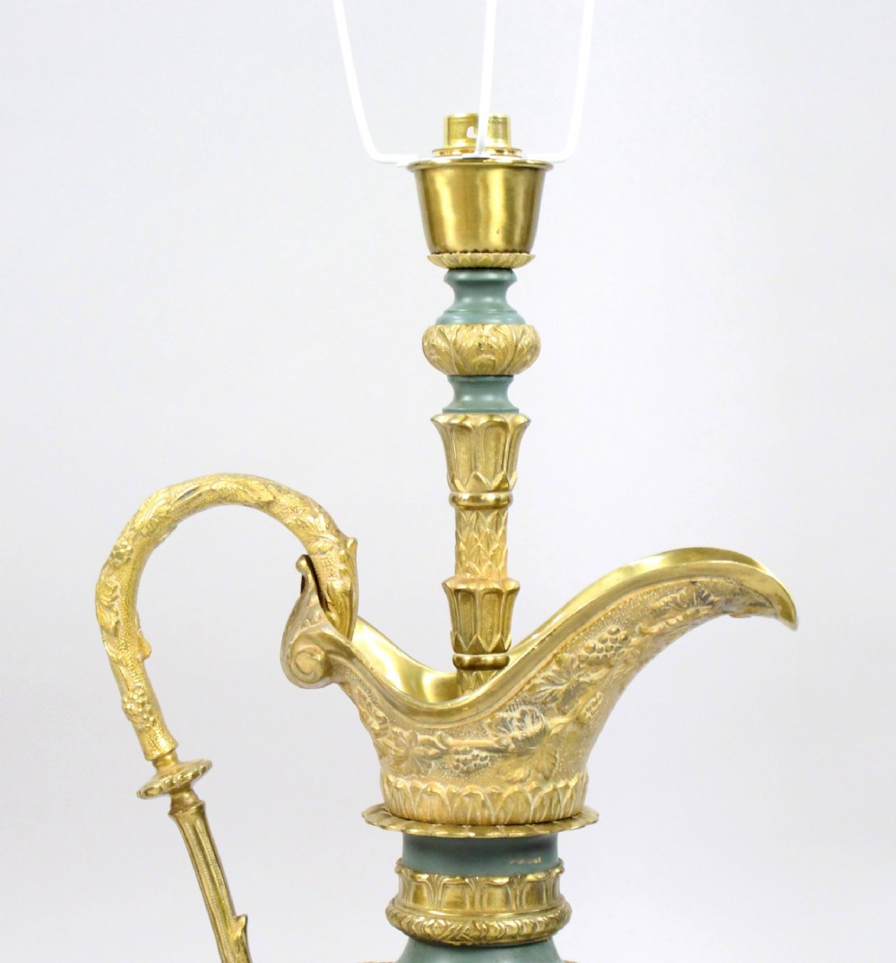 A pair of late nineteenth-century gilt metal table lamps fashioned in the shape of classical ewers with relief carving and green painted accents. View VI