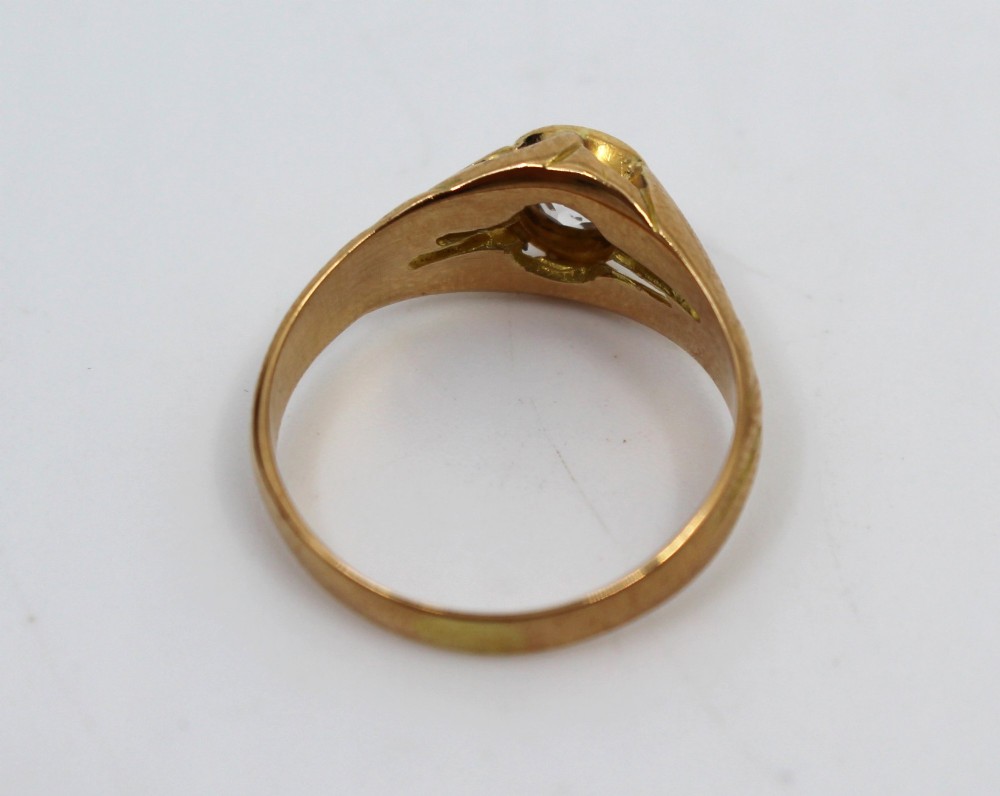 An antique rose gold ring featuring a central round old-cut diamond set within carved shoulders. View IV