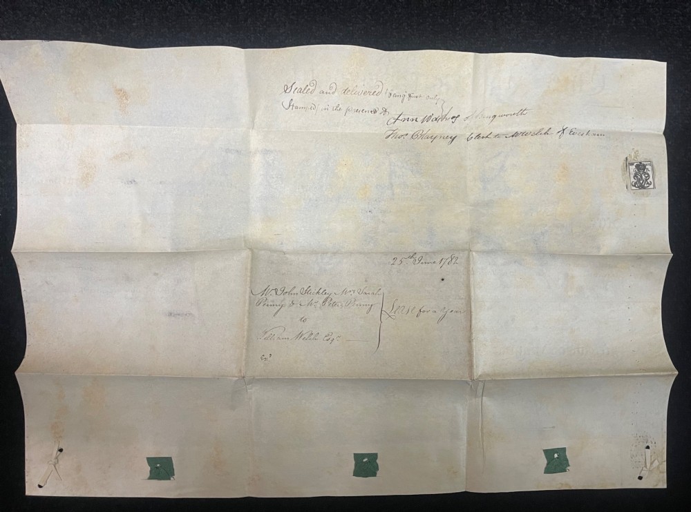An 1782 handwritten George III vellum tripartite legal indenture featuring ornate calligraphy, a blue revenue stamp, and three red wax seals along the bottom edge. View VI