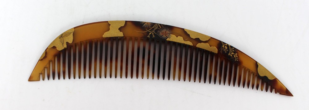A two-piece Japanese hair ornament set comprising a crescent comb and a slender pin, crafted from mottled amber tortoiseshell with gold lacquer botanical motifs. View III