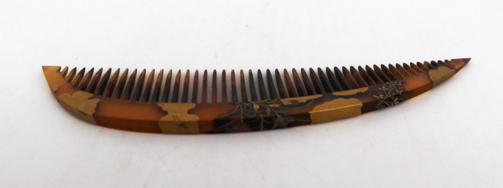 A two-piece Japanese hair ornament set comprising a crescent comb and a slender pin, crafted from mottled amber tortoiseshell with gold lacquer botanical motifs. View IV