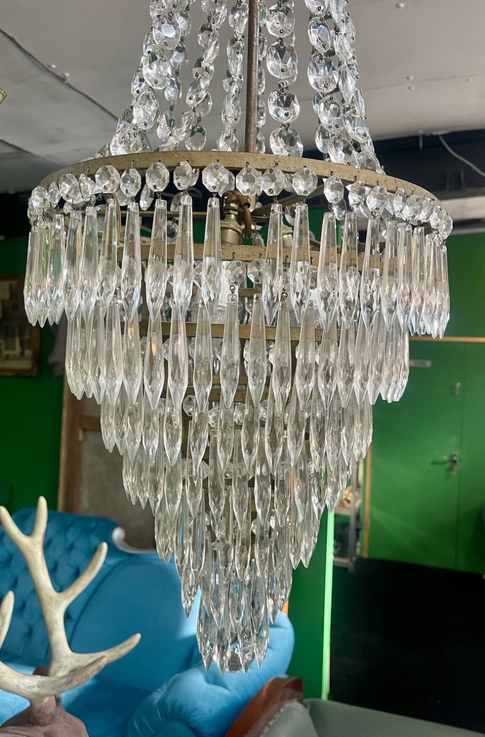 A French Empire style crystal waterfall chandelier with upper octagonal bead strands and lower cascading glass prisms attached to a brass band. View V