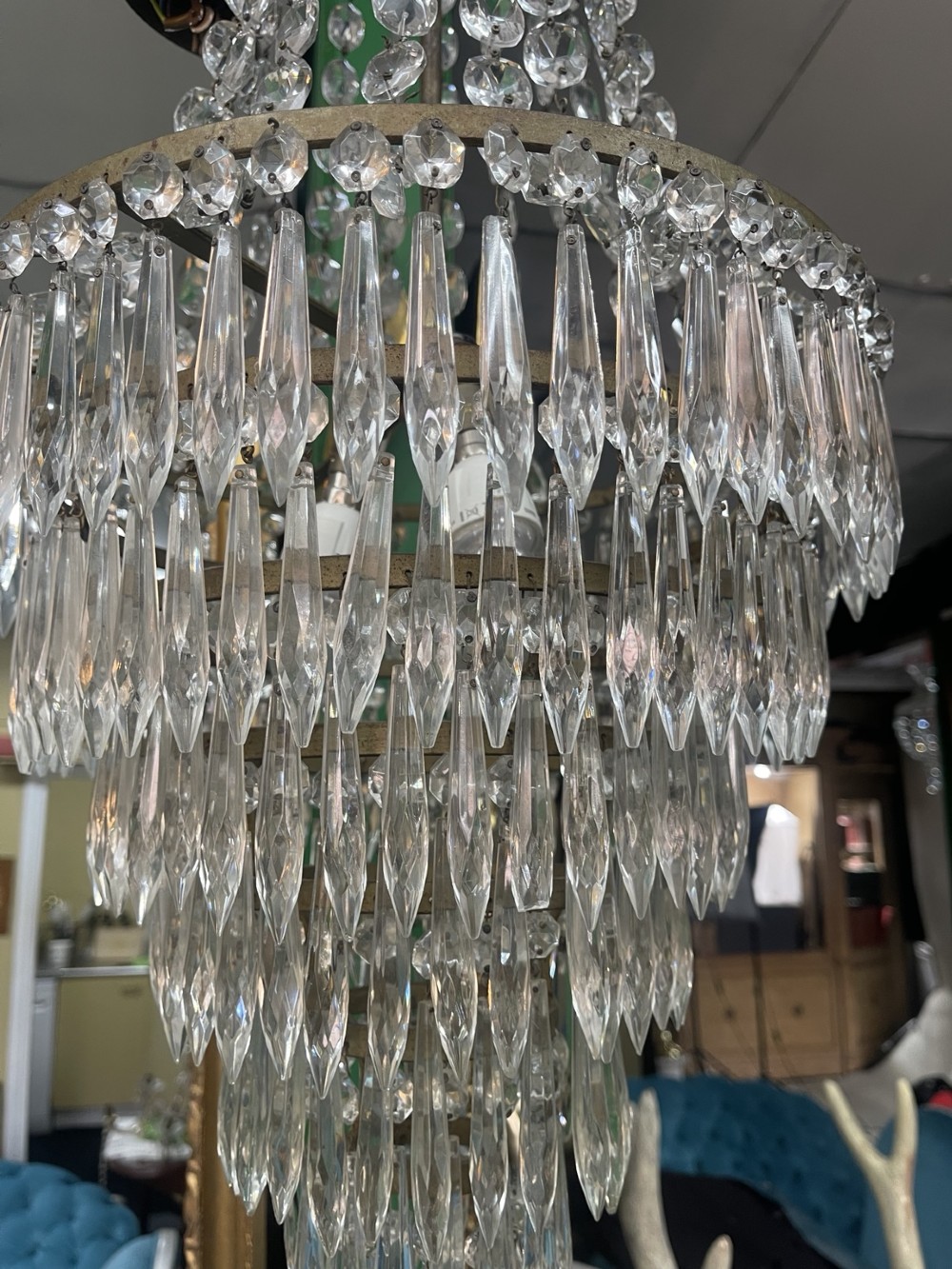 A French Empire style crystal waterfall chandelier with upper octagonal bead strands and lower cascading glass prisms attached to a brass band. View VI