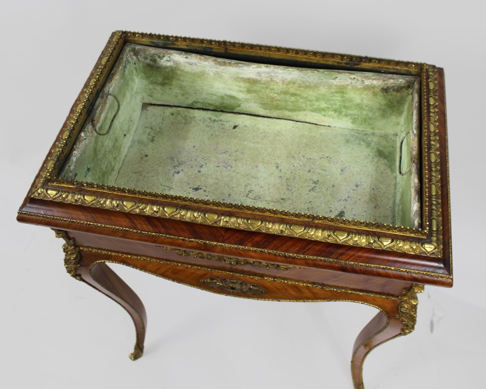 A 19th-century French kingwood jardiniere table featuring geometric parquetry inlay, ornate gilt-bronze mounts, cabriole legs, and a central floral porcelain plaque. View X
