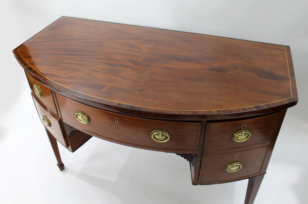 A George III bow-fronted mahogany serving table with brass oval handles, stringing inlay, and square tapered legs. View III