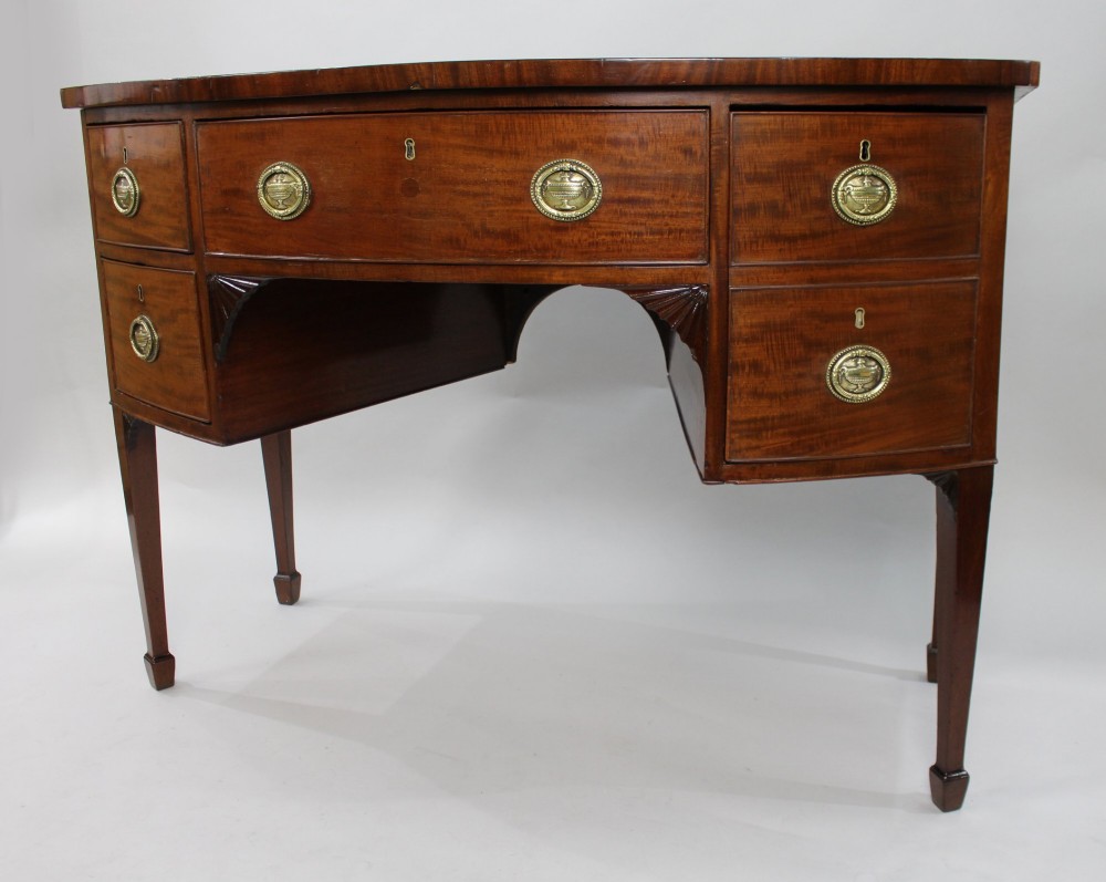 A George III bow-fronted mahogany serving table with brass oval handles, stringing inlay, and square tapered legs. View V