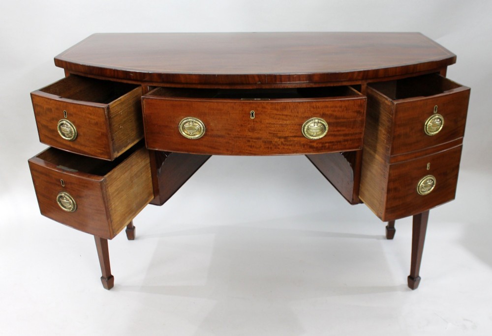 A George III bow-fronted mahogany serving table with brass oval handles, stringing inlay, and square tapered legs. View VI