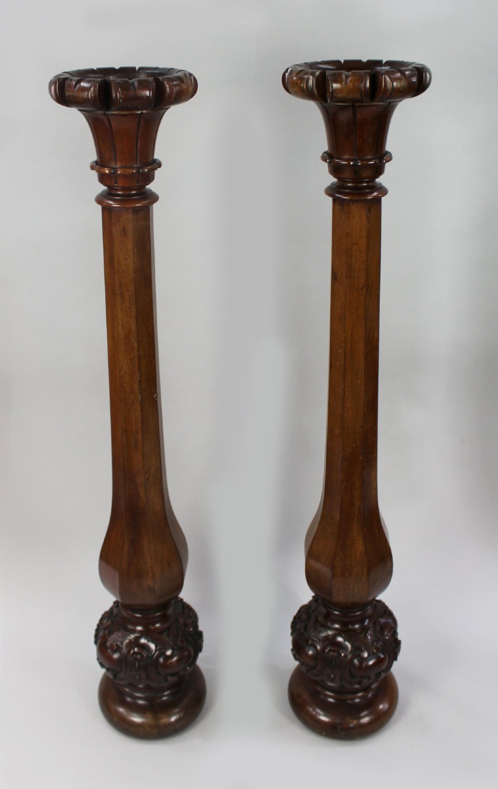A pair of tall early Victorian carved mahogany pedestals featuring faceted stems, fluted top capitals, and detailed bulbous carved bases. View II