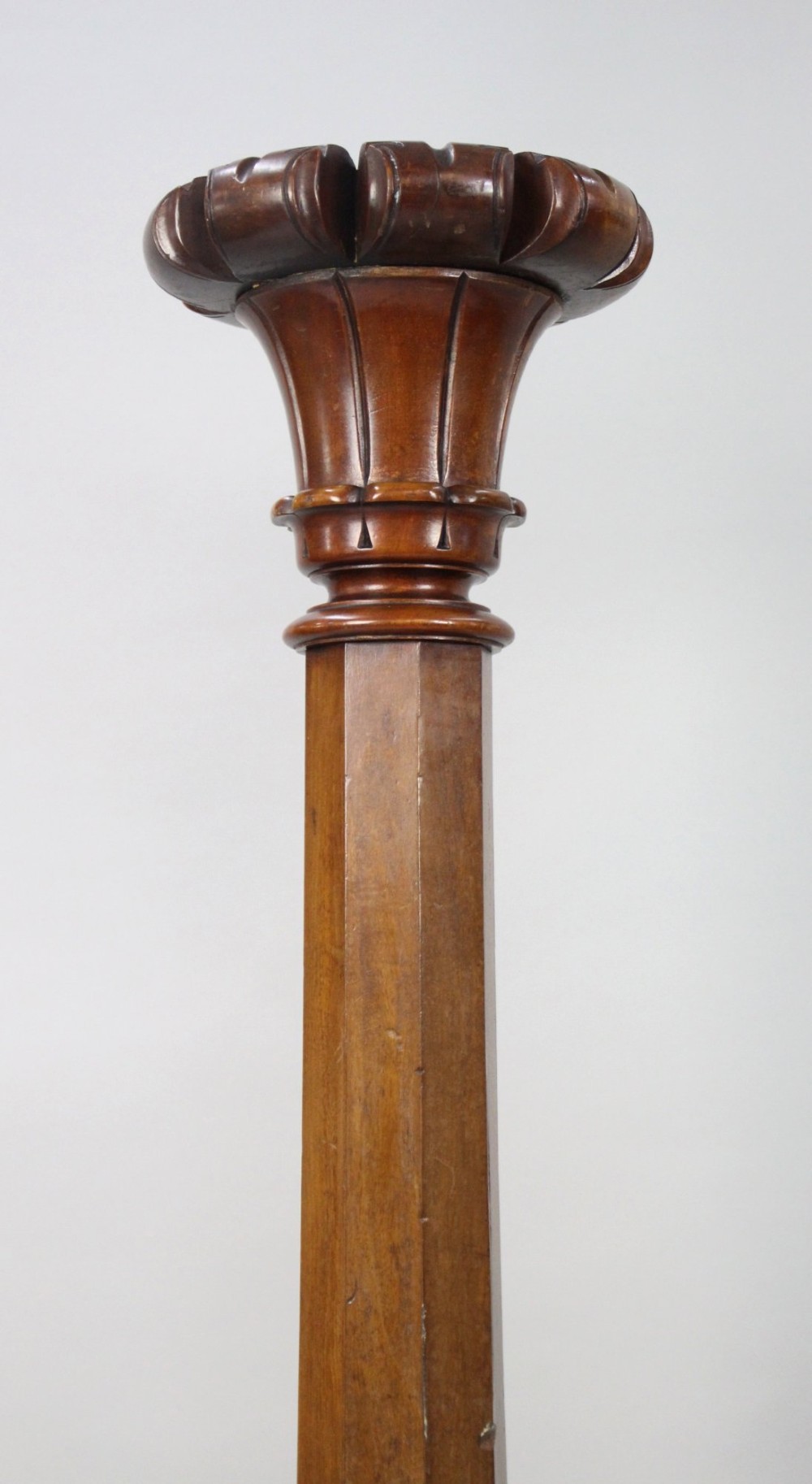 A pair of tall early Victorian carved mahogany pedestals featuring faceted stems, fluted top capitals, and detailed bulbous carved bases. View IV