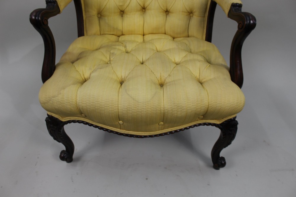 A Victorian mahogany button-back armchair with yellow tufted fabric upholstery, padded armrests, and carved cabriole front legs. View IV