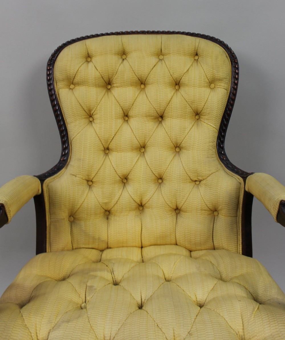 A Victorian mahogany button-back armchair with yellow tufted fabric upholstery, padded armrests, and carved cabriole front legs. View VII