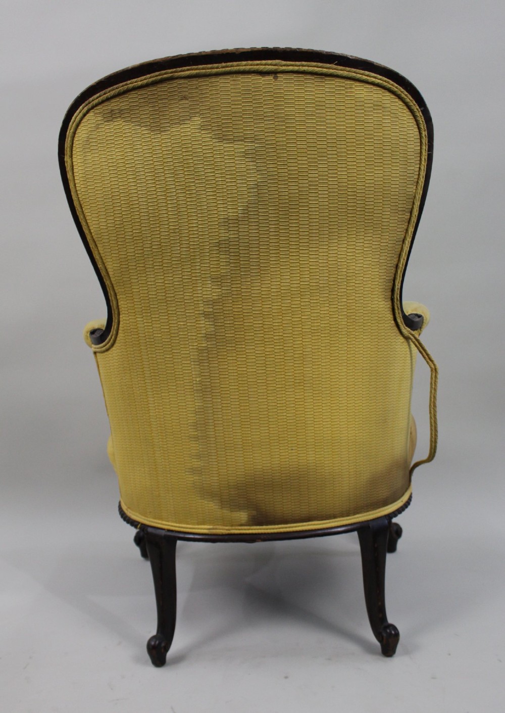 A Victorian mahogany button-back armchair with yellow tufted fabric upholstery, padded armrests, and carved cabriole front legs. View X