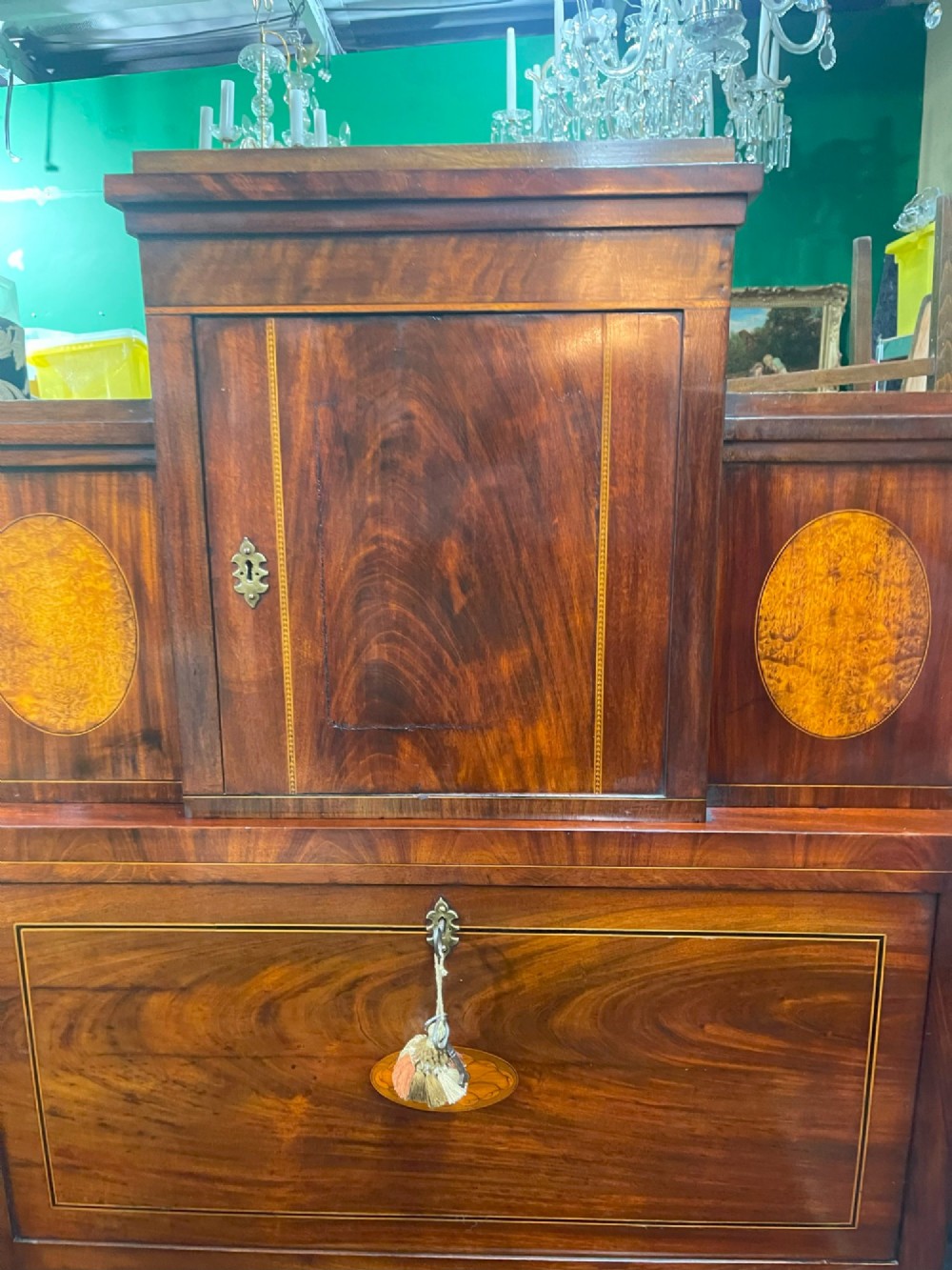 A tall Georgian mahogany secretaire chest featuring stepped upper cabinets with oval satinwood inlay, a pull-out writing drawer, and three lower drawers with brass handles. View II