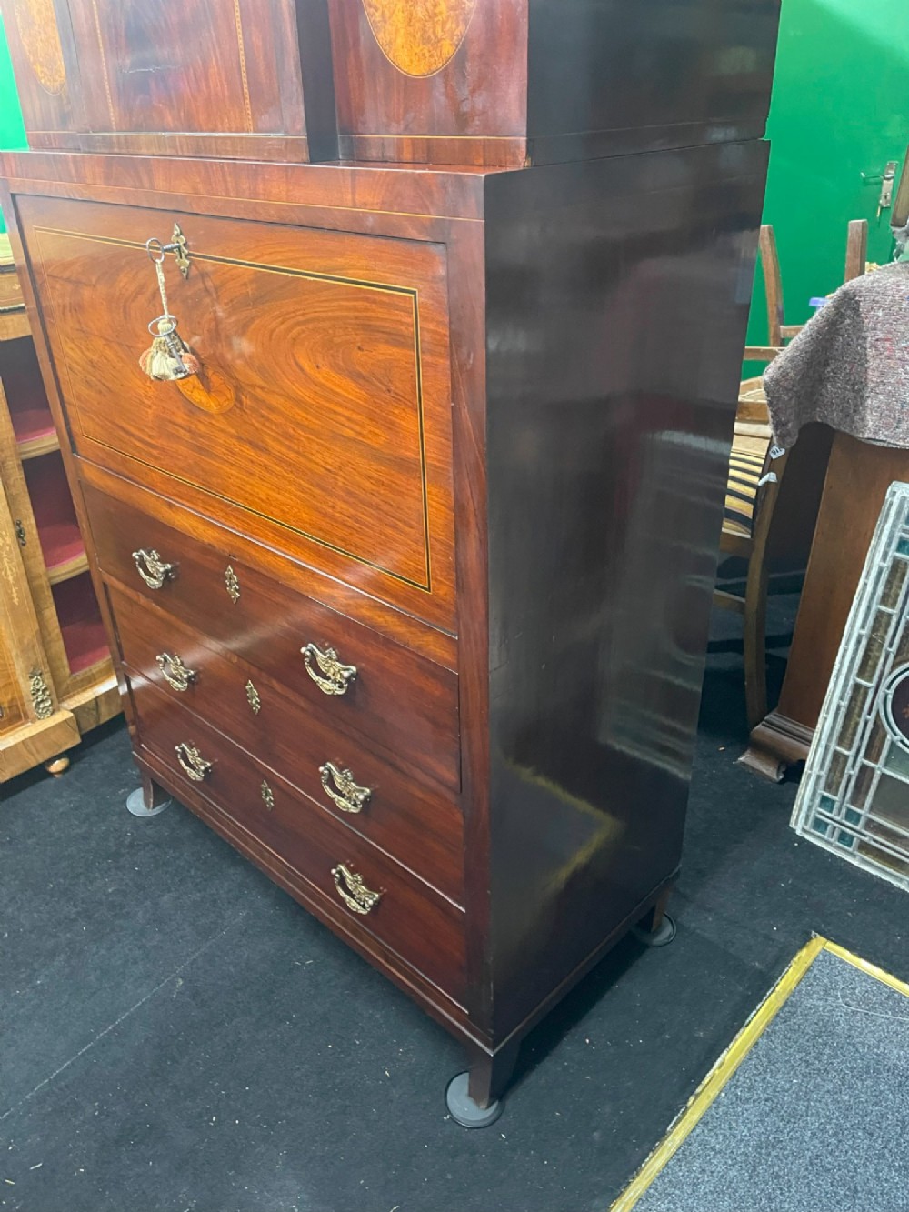 A tall Georgian mahogany secretaire chest featuring stepped upper cabinets with oval satinwood inlay, a pull-out writing drawer, and three lower drawers with brass handles. View V