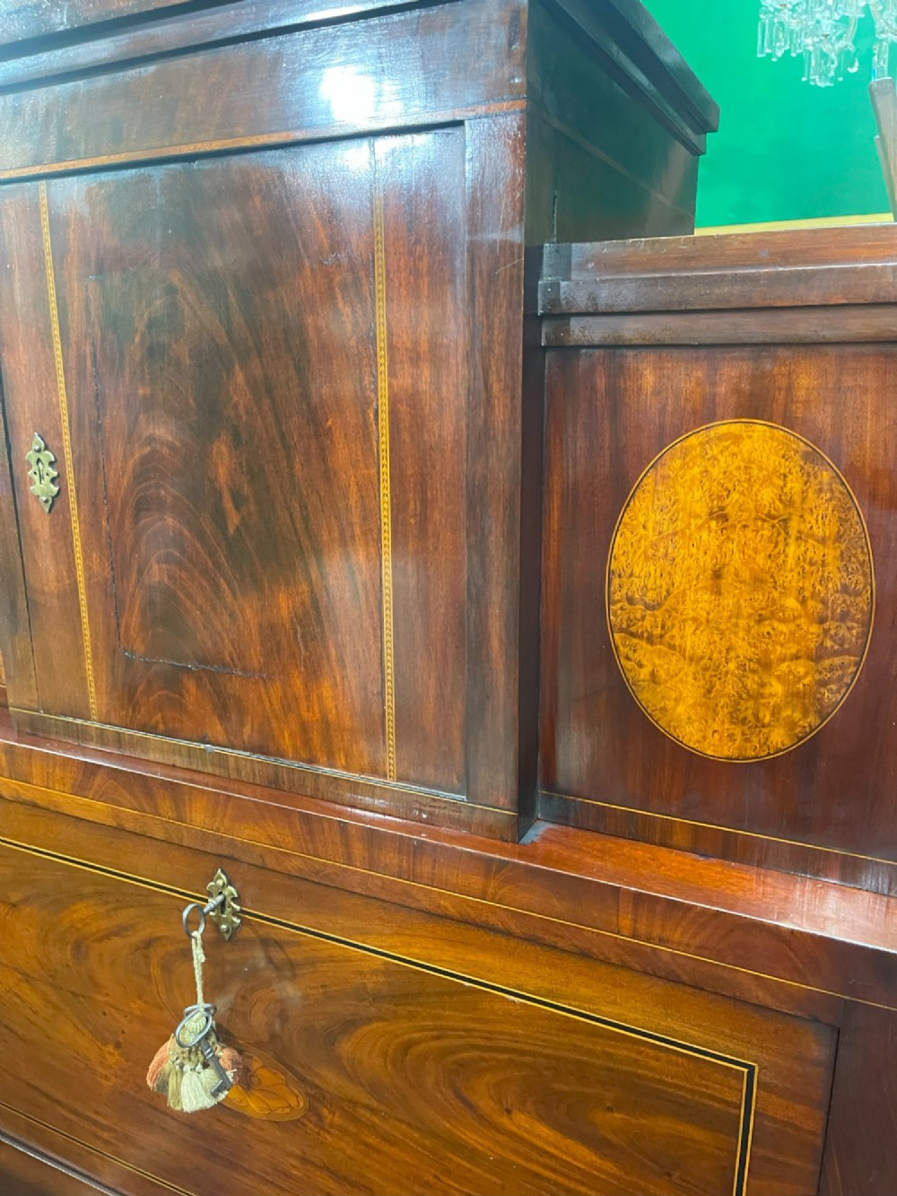 A tall Georgian mahogany secretaire chest featuring stepped upper cabinets with oval satinwood inlay, a pull-out writing drawer, and three lower drawers with brass handles. View VI
