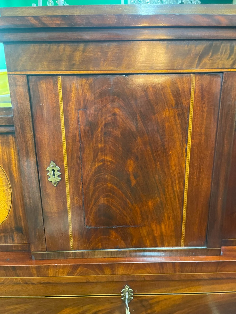 A tall Georgian mahogany secretaire chest featuring stepped upper cabinets with oval satinwood inlay, a pull-out writing drawer, and three lower drawers with brass handles. View VII