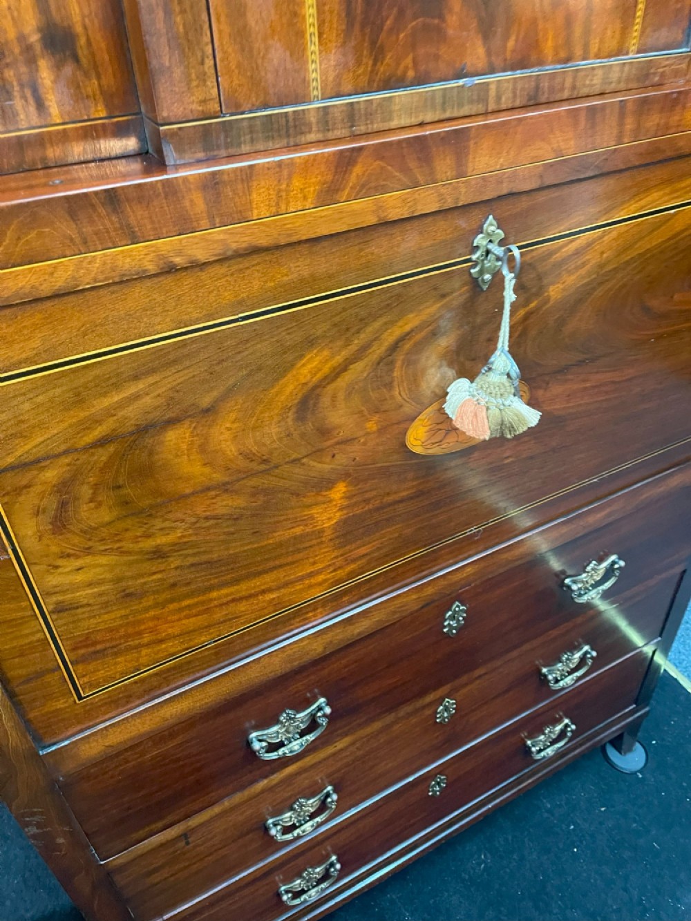 A tall Georgian mahogany secretaire chest featuring stepped upper cabinets with oval satinwood inlay, a pull-out writing drawer, and three lower drawers with brass handles. View X
