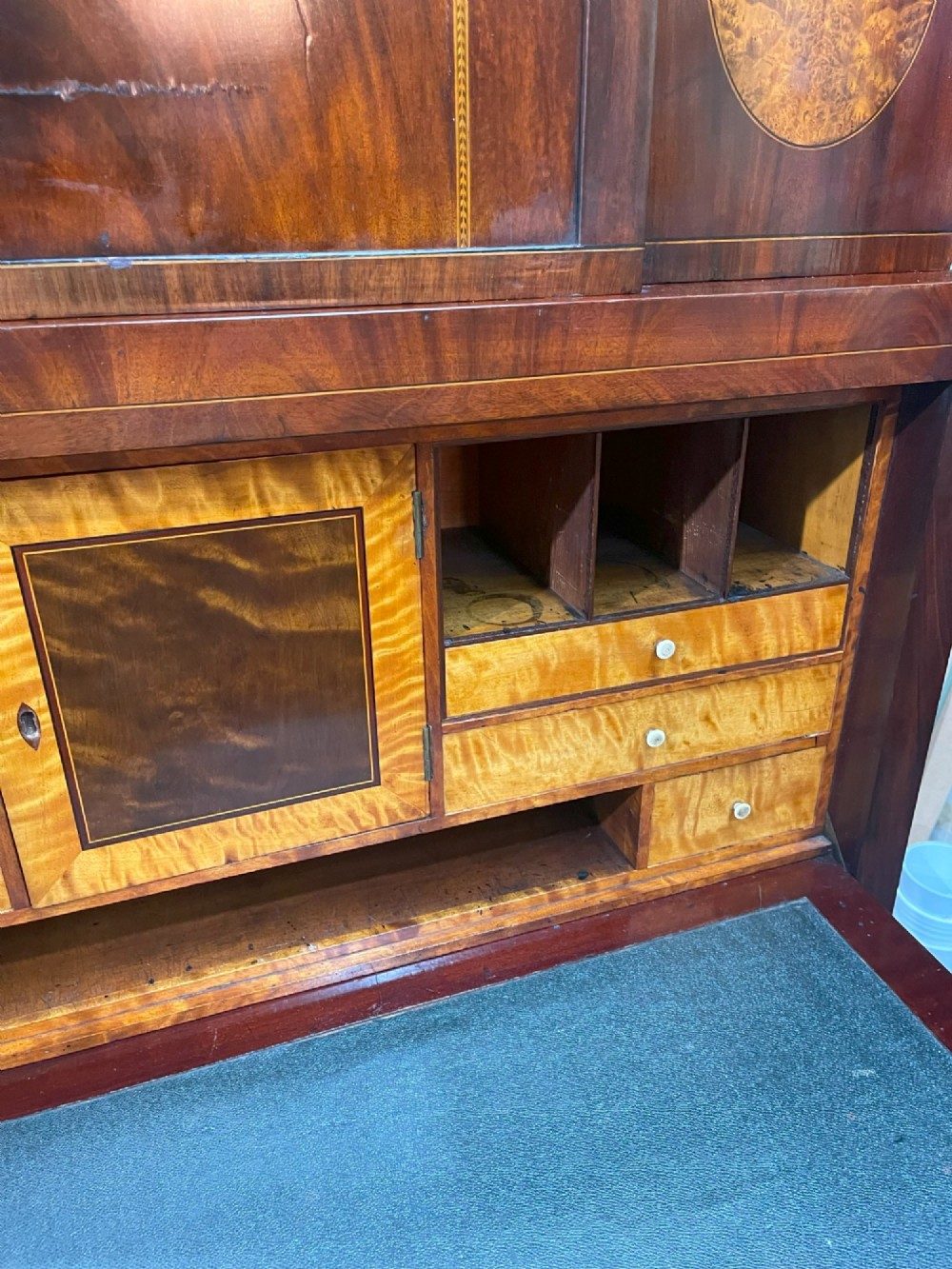 A tall Georgian mahogany secretaire chest featuring stepped upper cabinets with oval satinwood inlay, a pull-out writing drawer, and three lower drawers with brass handles. View XV