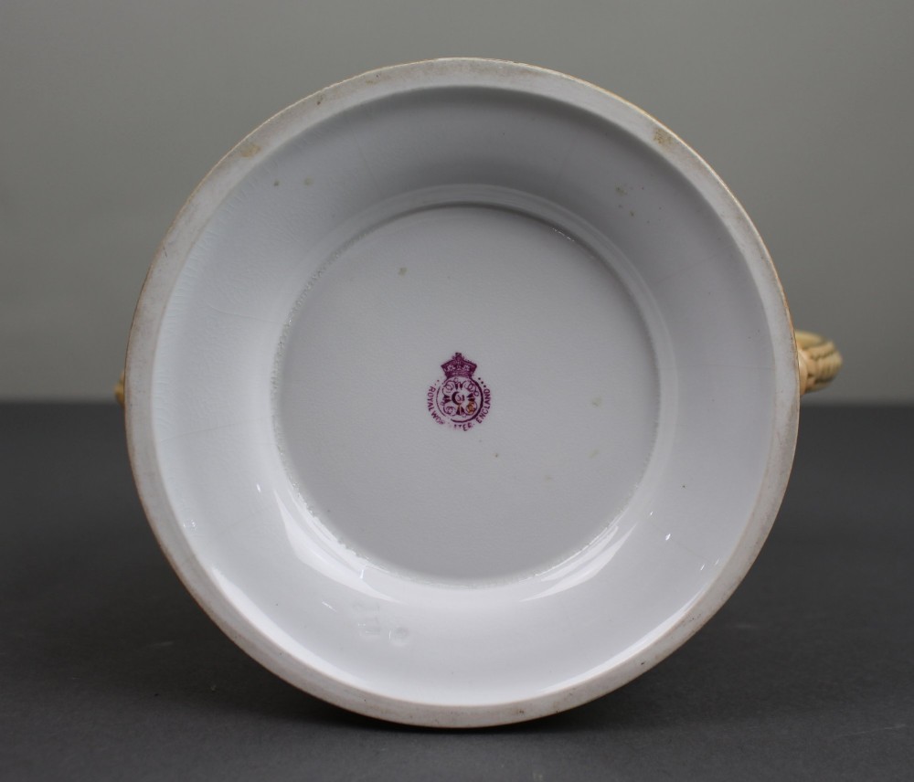 An Edwardian Royal Worcester porcelain loving cup featuring twin gilded scroll handles, a cream blush ground, hand-painted floral motifs, and a central gilt monogram. View III