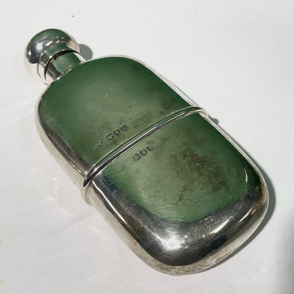 A late Victorian sterling silver spirit flask featuring a domed top and visible London hallmark stamps on the body. View III