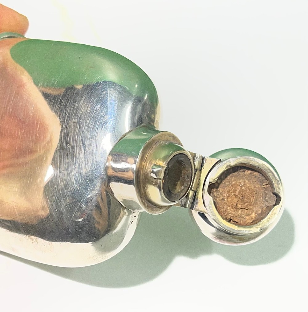 A late Victorian sterling silver spirit flask featuring a domed top and visible London hallmark stamps on the body. View IV
