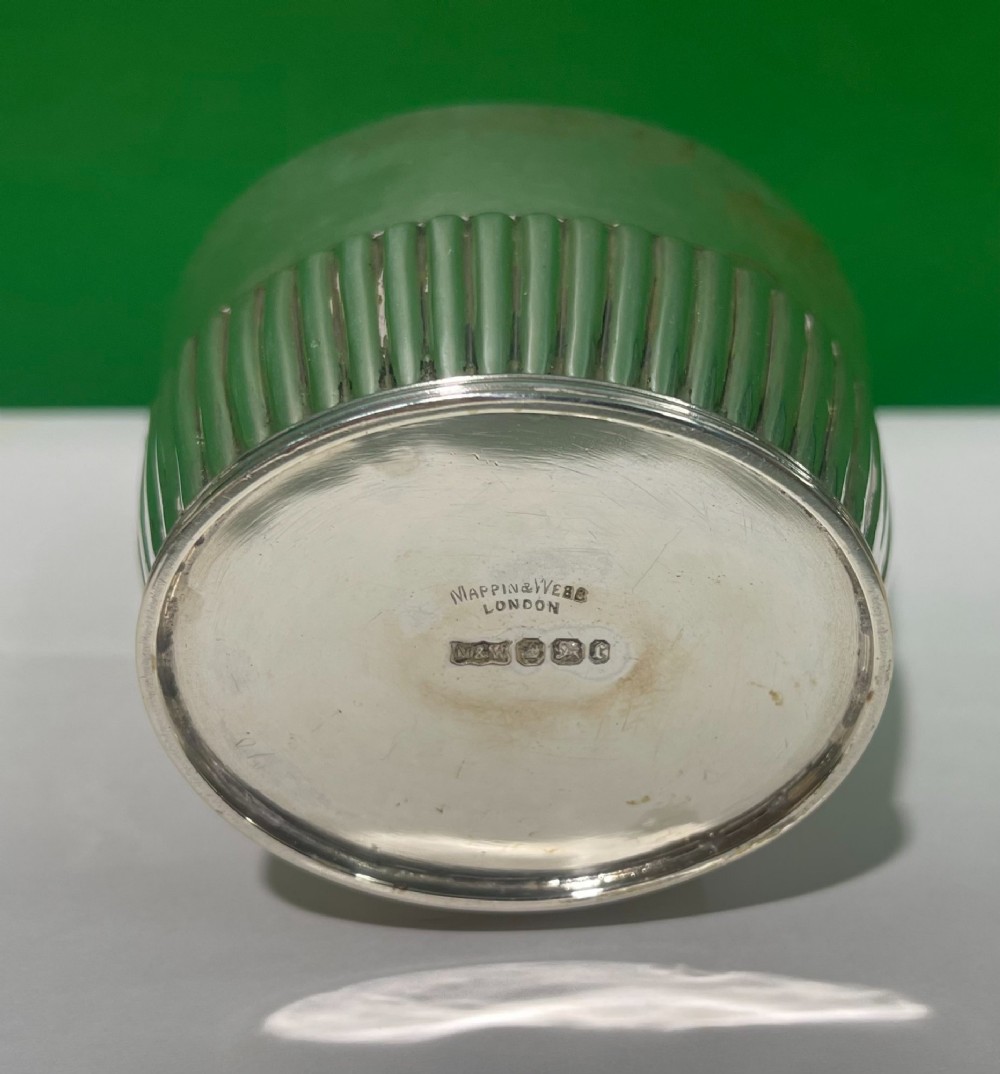 An Edwardian sterling silver jar featuring vertical fluted decoration around the lower body and official hallmarking stamped on the neck. View III