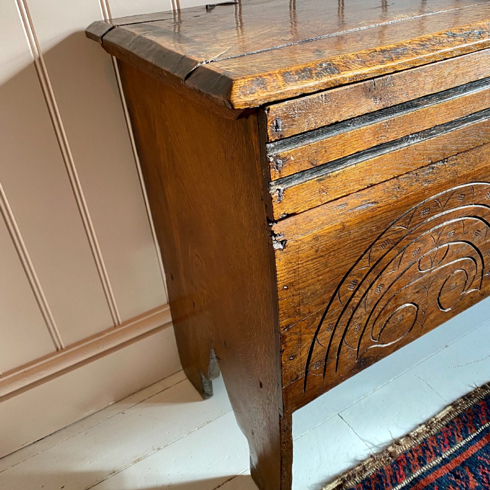 A 17th-century oak coffer displaying hand-carved lunette motifs across the front panel and an iron lockplate. View III