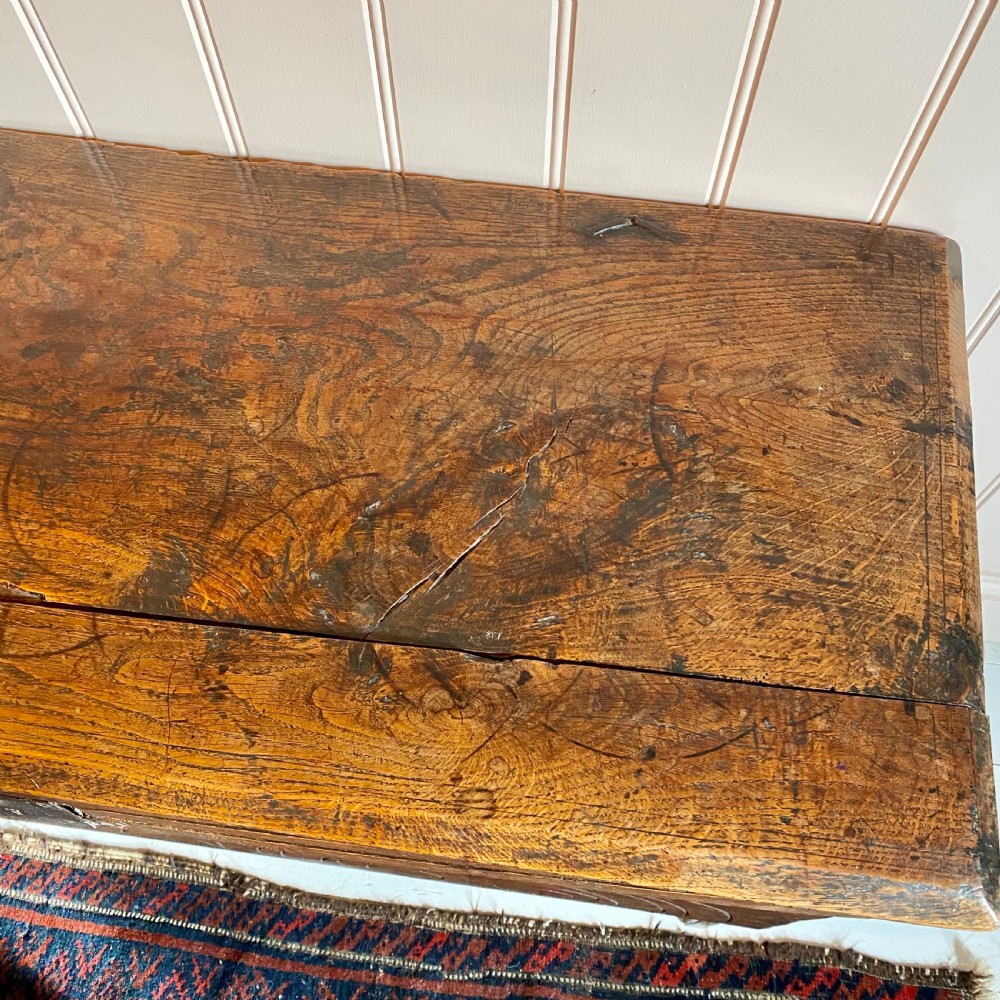 A 17th-century oak coffer displaying hand-carved lunette motifs across the front panel and an iron lockplate. View VII