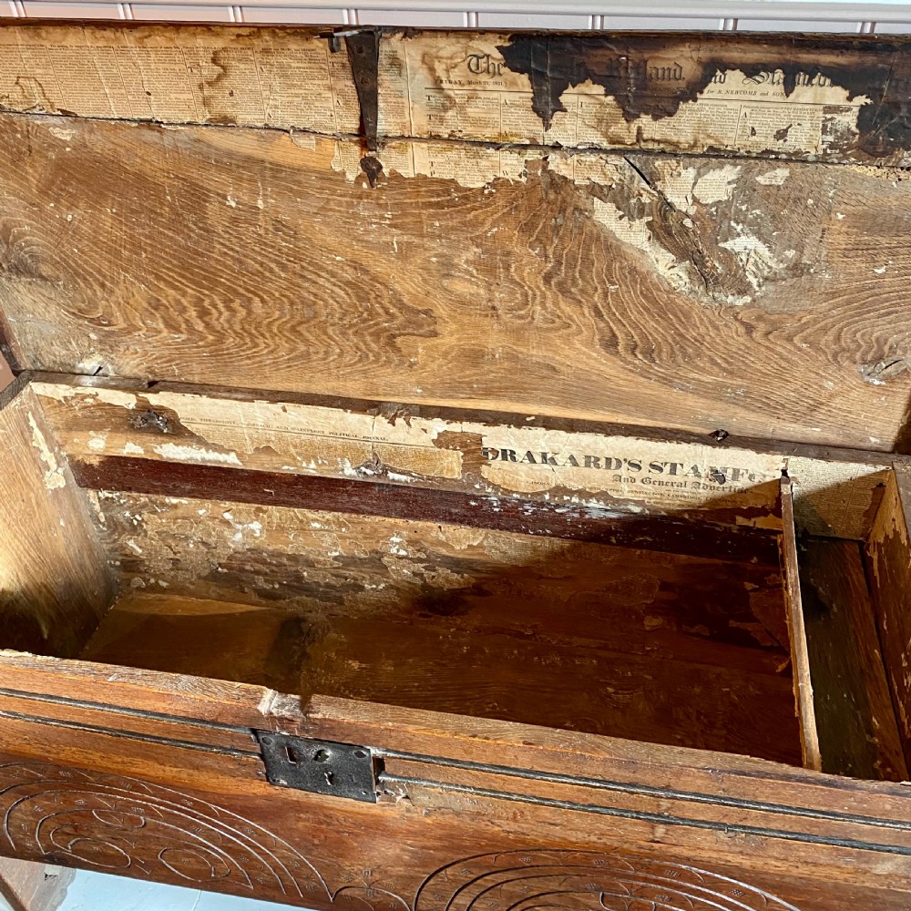 A 17th-century oak coffer displaying hand-carved lunette motifs across the front panel and an iron lockplate. View VIII