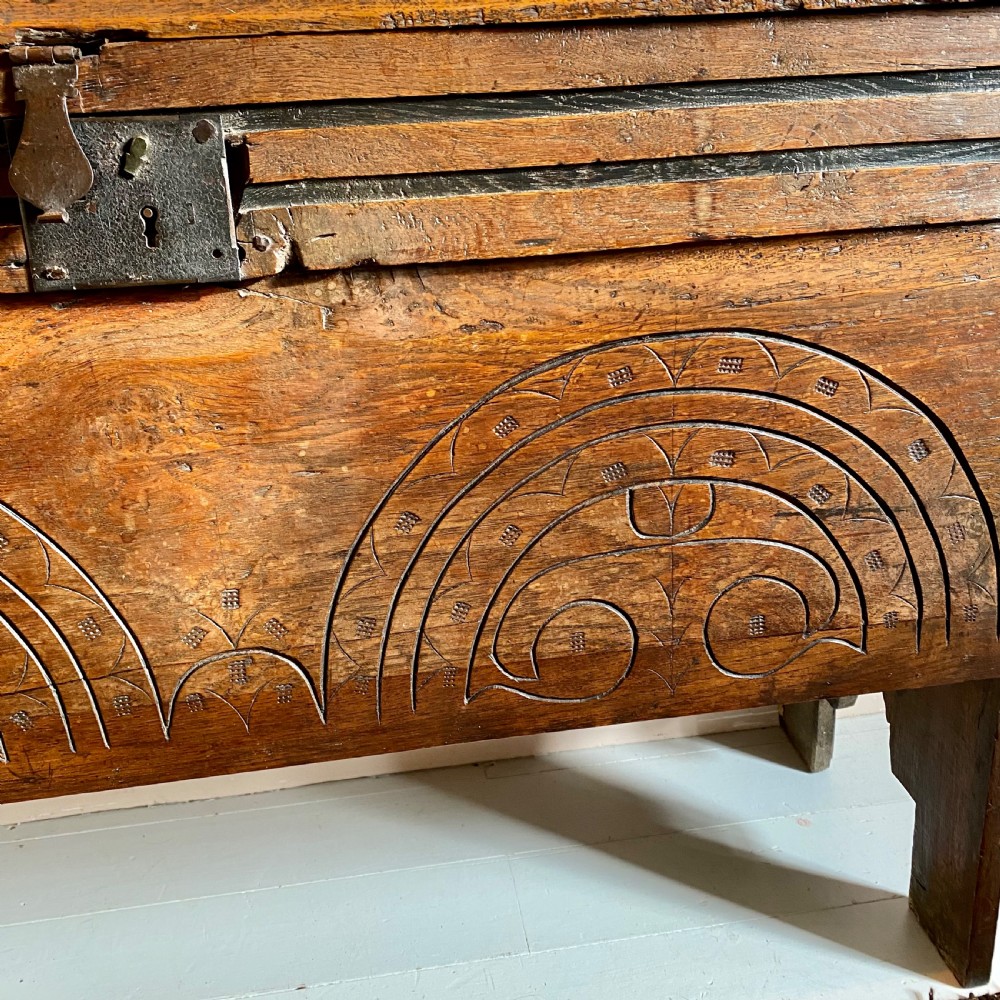 A 17th-century oak coffer displaying hand-carved lunette motifs across the front panel and an iron lockplate. View IX