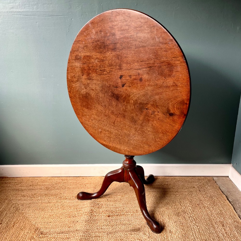 A Georgian mahogany tilt-top tripod table featuring a circular top, turned stem with a spiral carved knop, and three cabriole legs with pad feet. View II