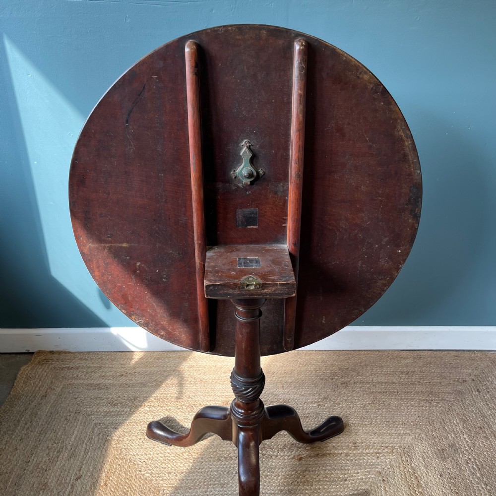 A Georgian mahogany tilt-top tripod table featuring a circular top, turned stem with a spiral carved knop, and three cabriole legs with pad feet. View VI