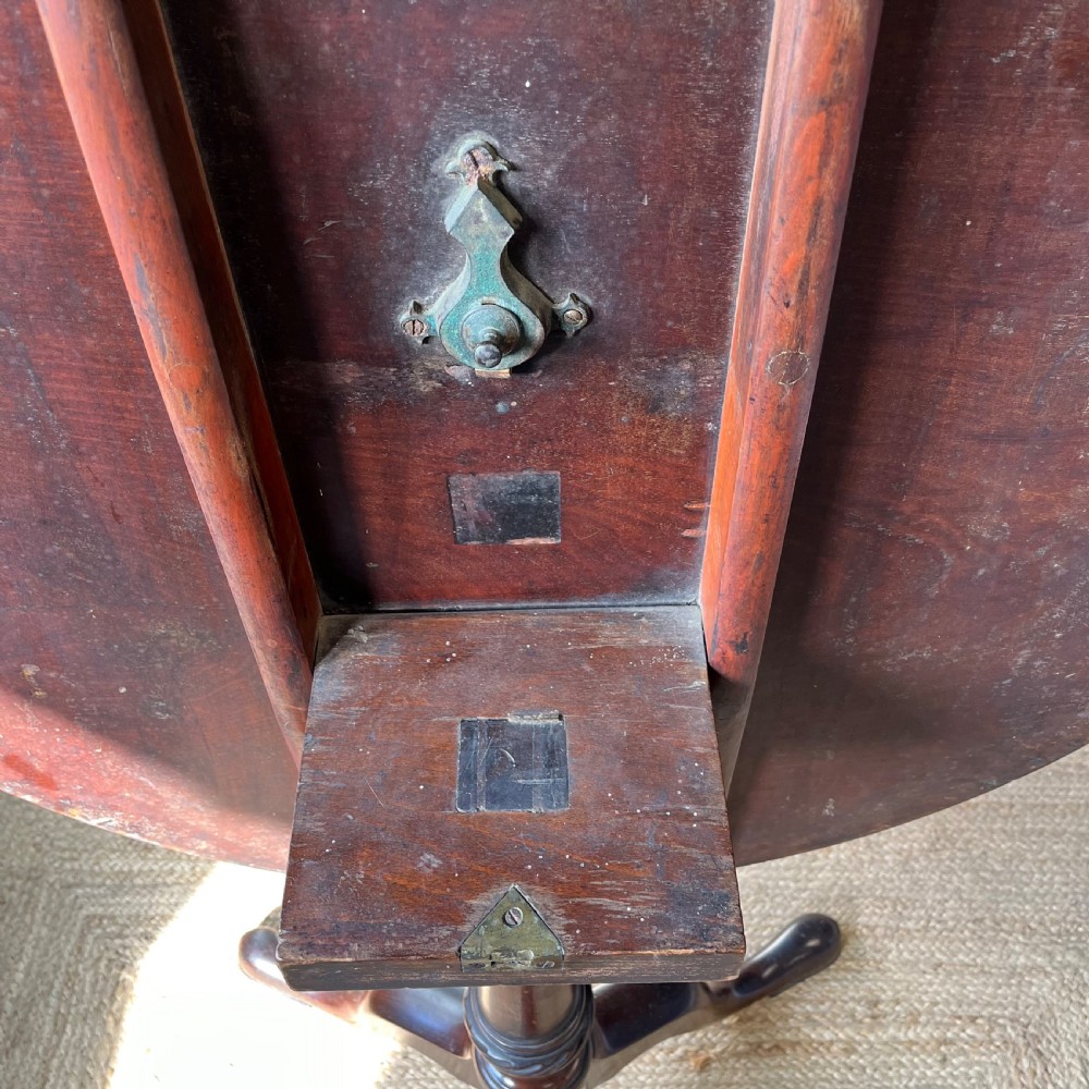 A Georgian mahogany tilt-top tripod table featuring a circular top, turned stem with a spiral carved knop, and three cabriole legs with pad feet. View VII