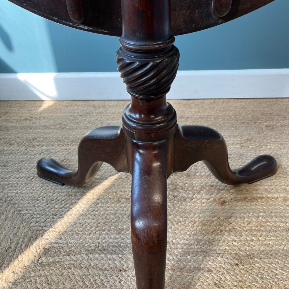 A Georgian mahogany tilt-top tripod table featuring a circular top, turned stem with a spiral carved knop, and three cabriole legs with pad feet. View VIII