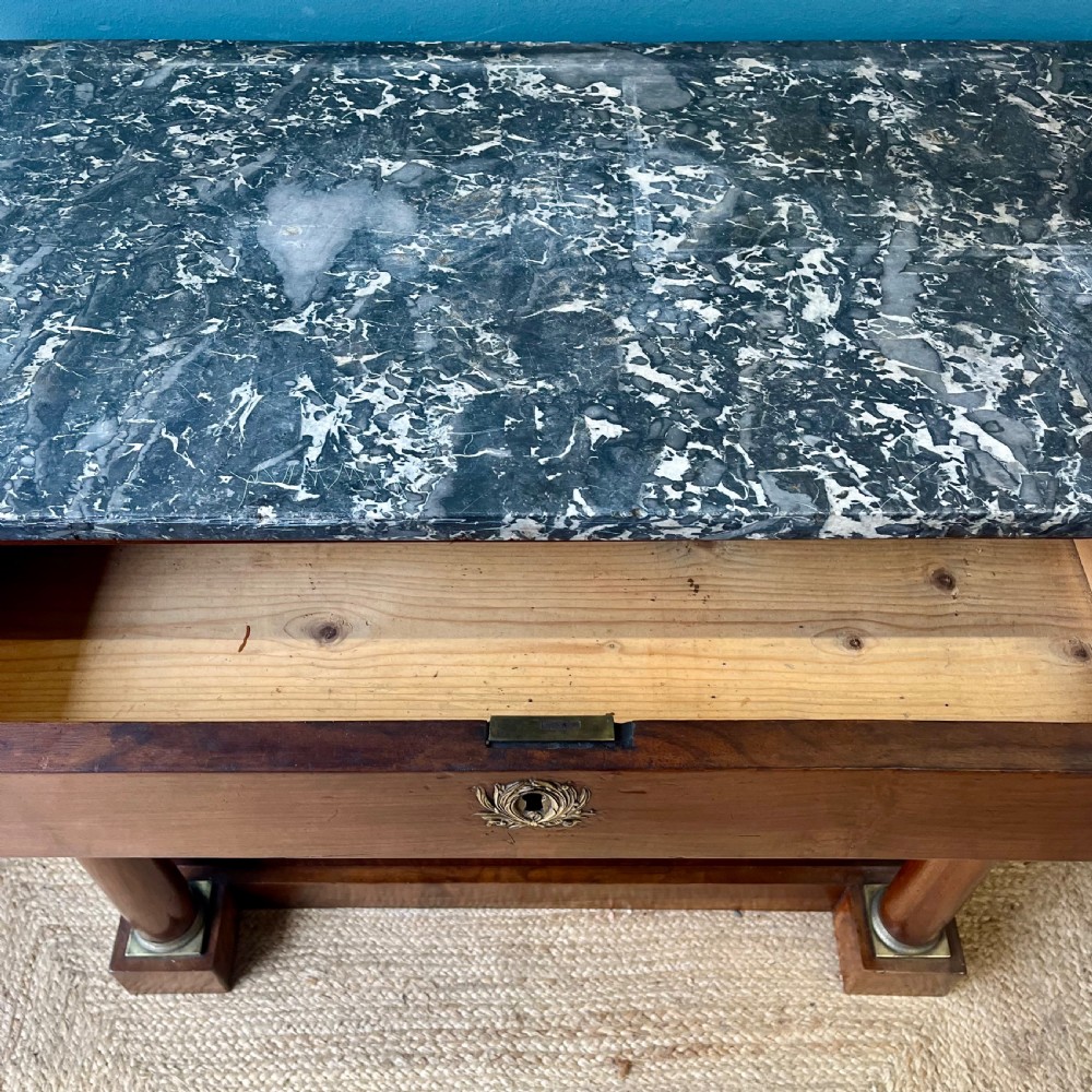 A 19th-century French walnut console table featuring a grey variegated marble top, single frieze drawer, and column legs on a plinth base. View XI